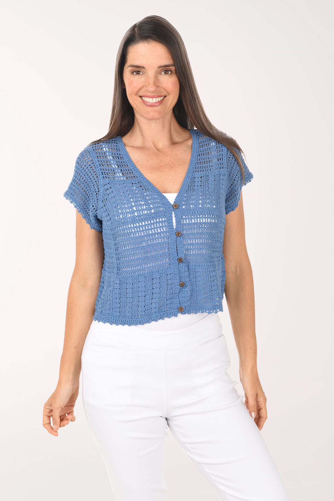Woman wearing a blue crochet top with buttons on a white background