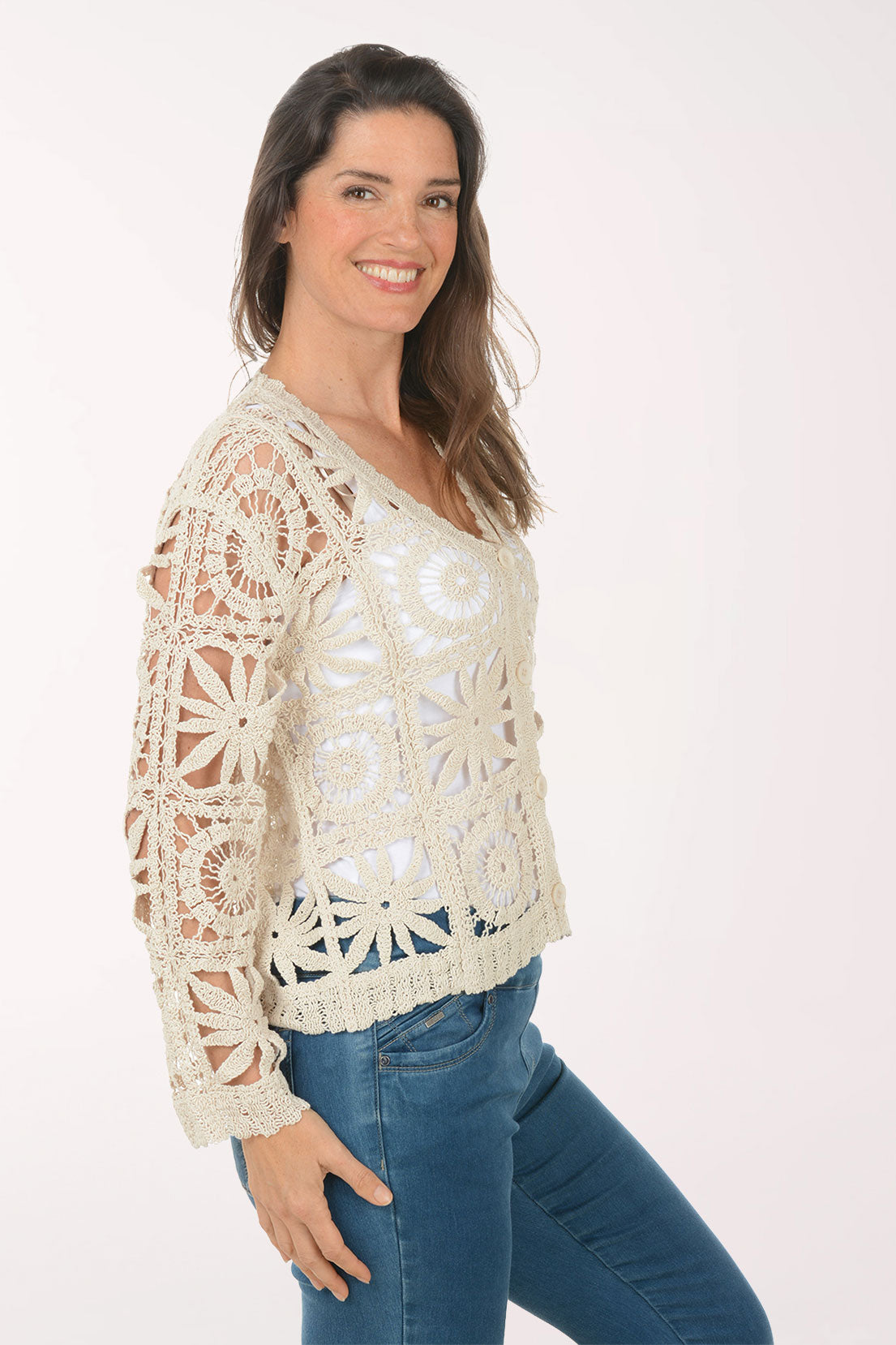 Woman wearing a beige crochet cardigan.