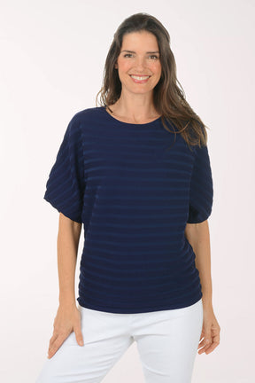 Woman wearing a short sleeve boxy navy top.