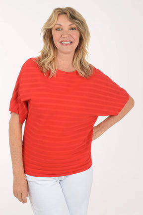 Woman wearing a short sleeve boxy red top.