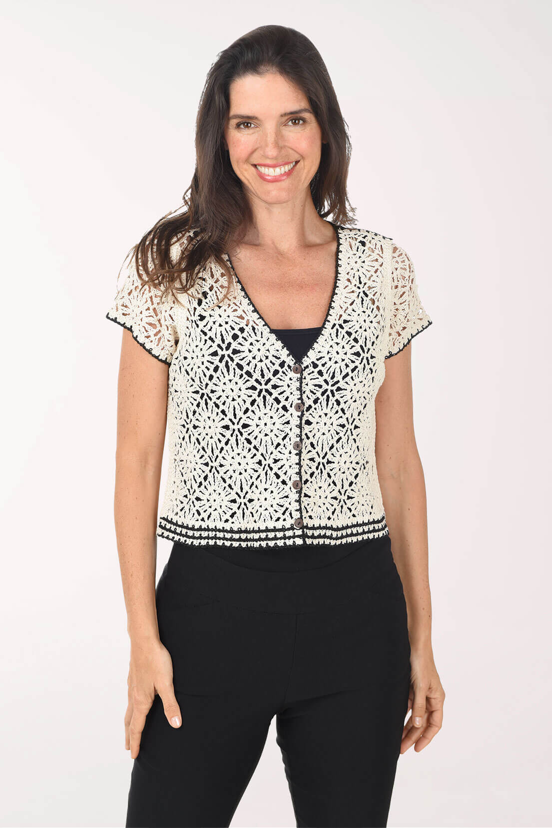 Woman wearing a black and white patterned top with a plain background