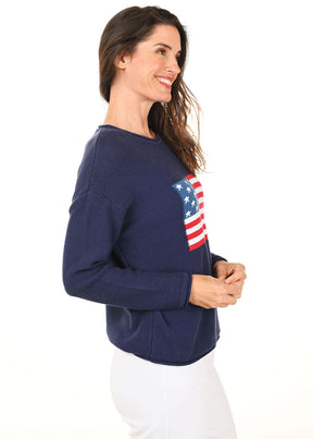 Woman wearing a navy blue sweater with an American flag design on a white background