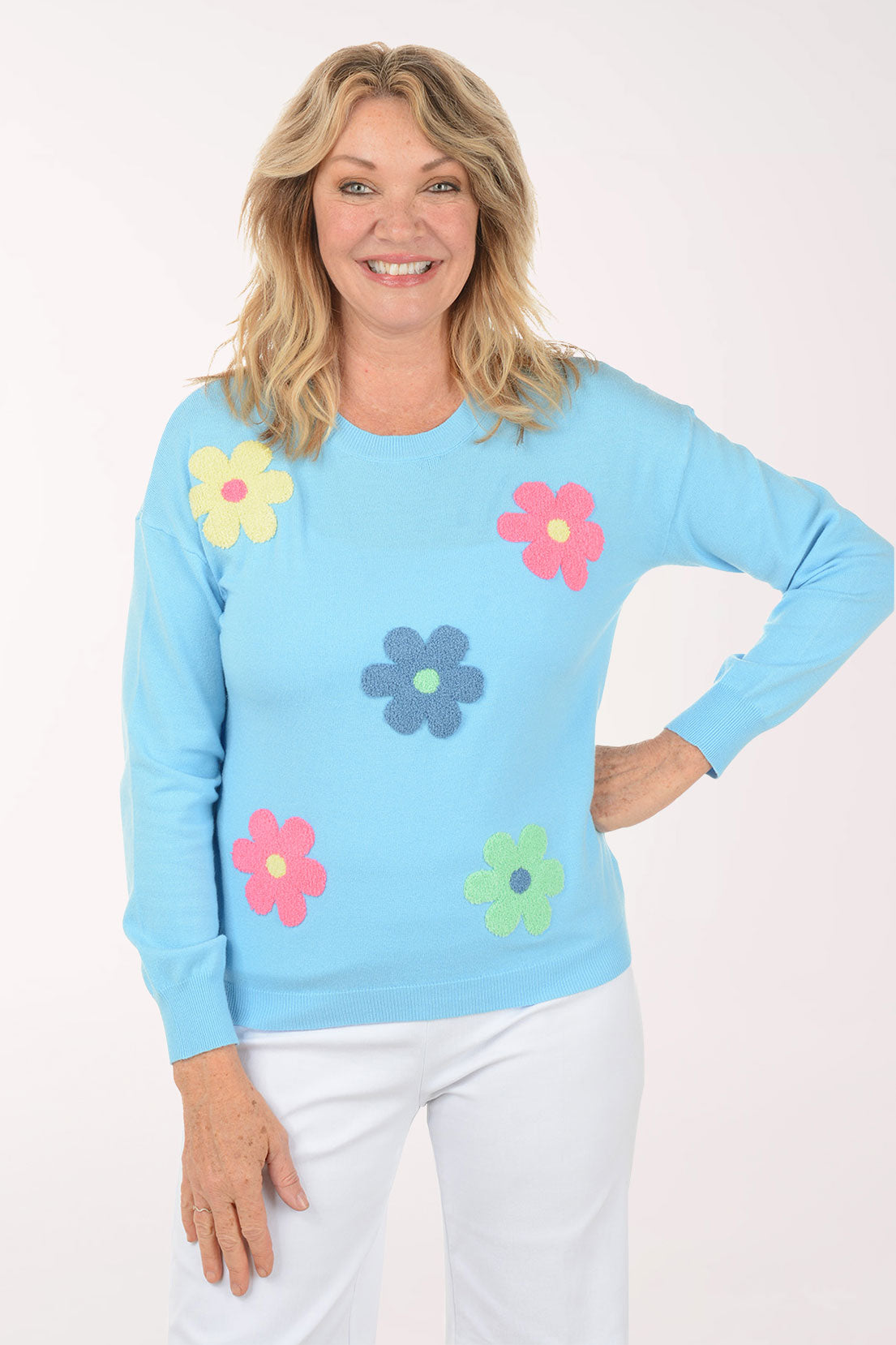 A woman wearing a blue sweater with flowers.