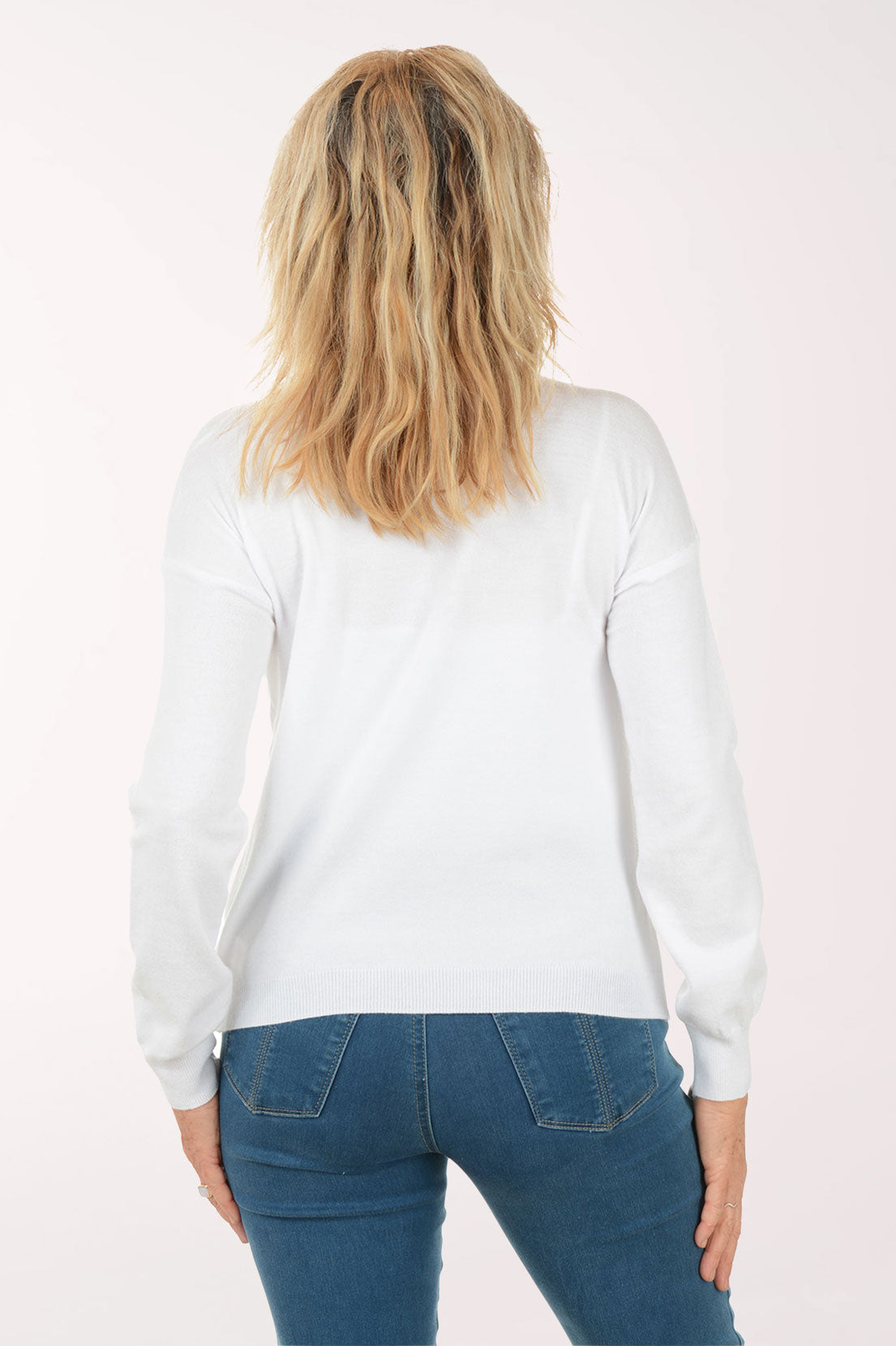 A woman wearing a white sweater with flowers.