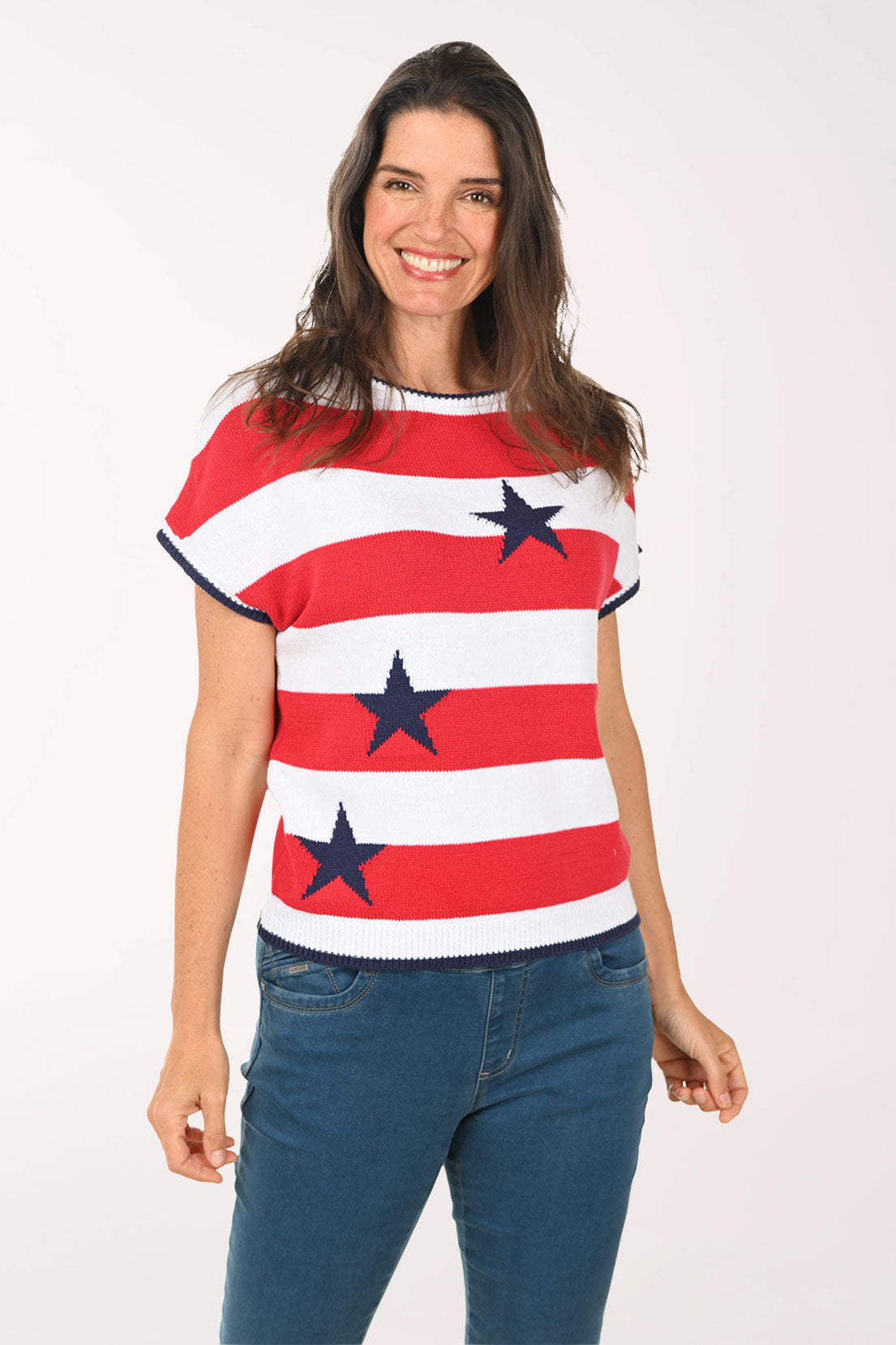 Woman wearing a red, white, and blue striped shirt with star patterns on a plain background
