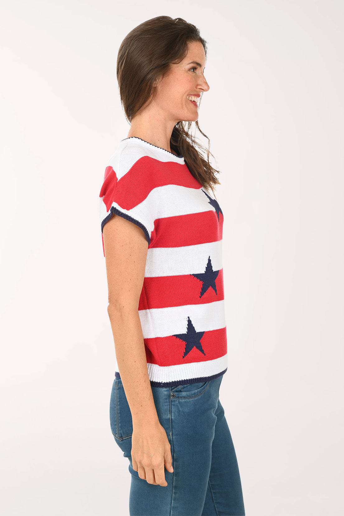 Woman wearing a red, white, and blue striped shirt with star patterns on a plain background