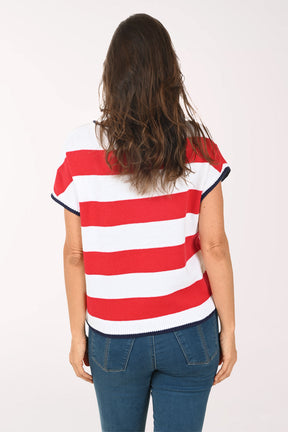 Woman wearing a red, white, and blue striped shirt with star patterns on a plain background