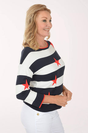 Woman wearing a navy and white striped sweater with red stars on a white background