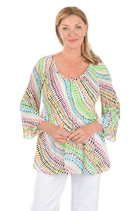 Woman wearing a colorful patterned top on a white background. Second front shot.