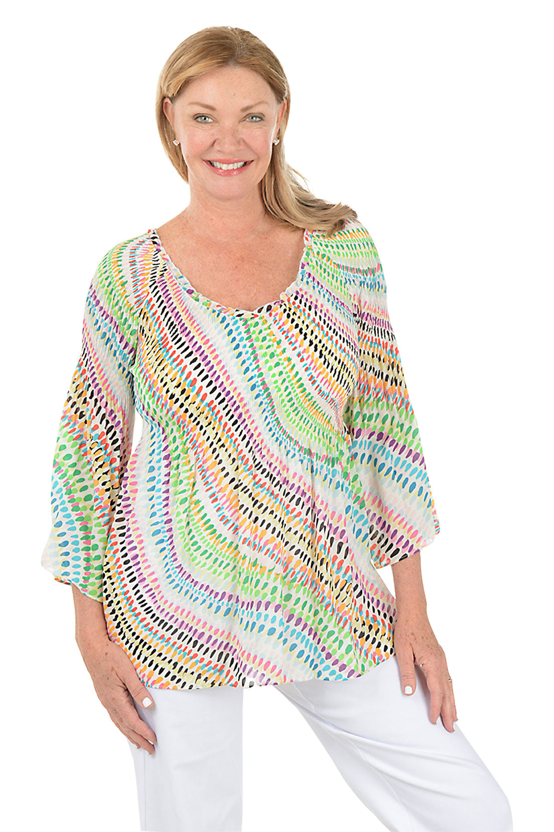 Woman wearing a colorful patterned top on a white background.