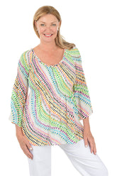 Woman wearing a colorful patterned top on a white background.