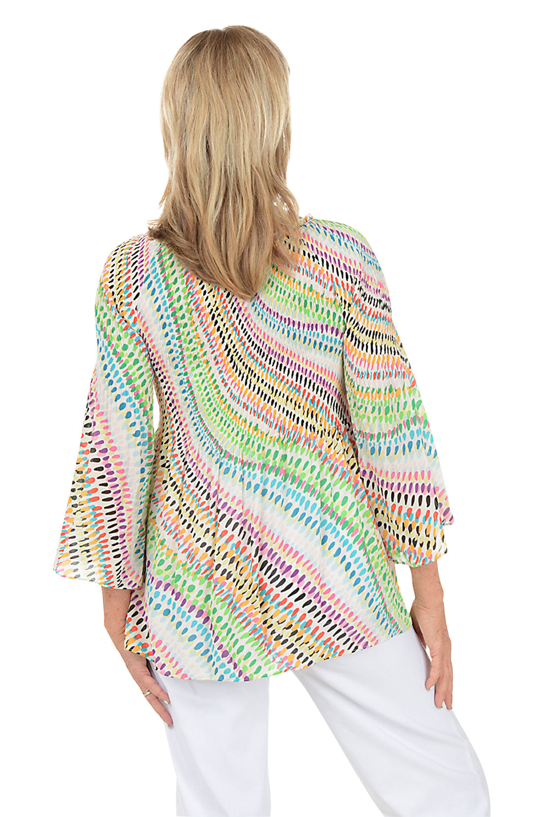 Woman wearing a colorful patterned top on a white background. Back shot.