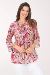 Woman wearing a colorful patterned blouse on a white background