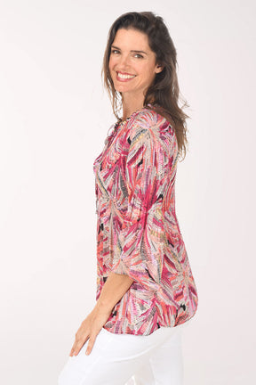 Woman wearing a colorful patterned blouse on a white background