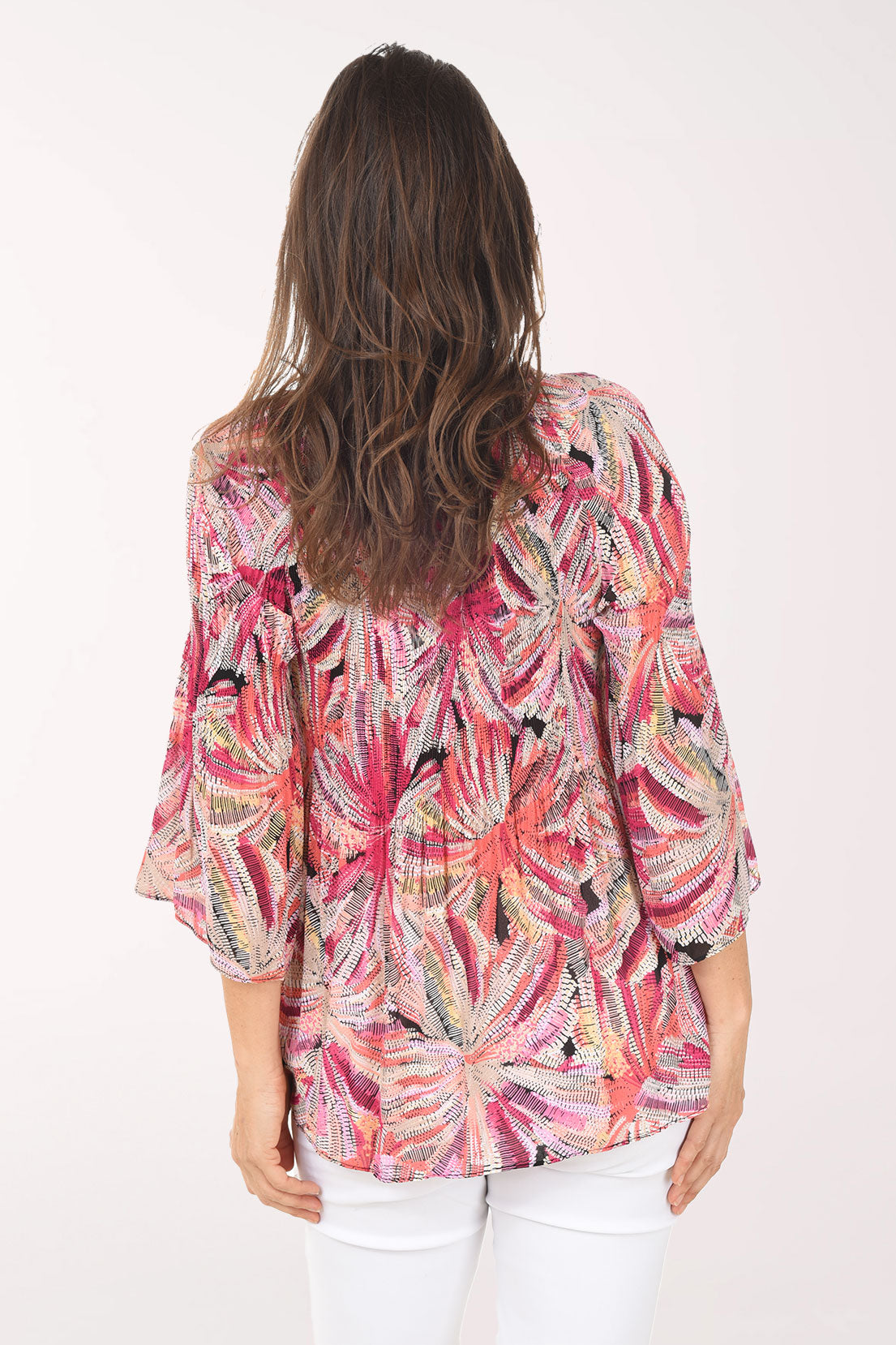 Woman wearing a colorful patterned blouse on a white background