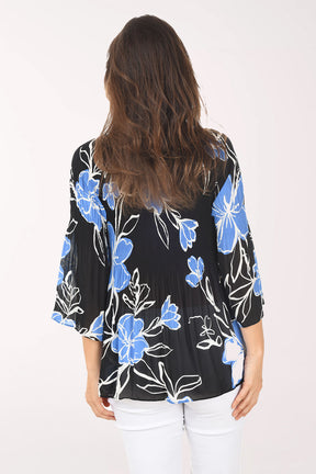 Woman wearing a black floral blouse with blue flowers on a white background