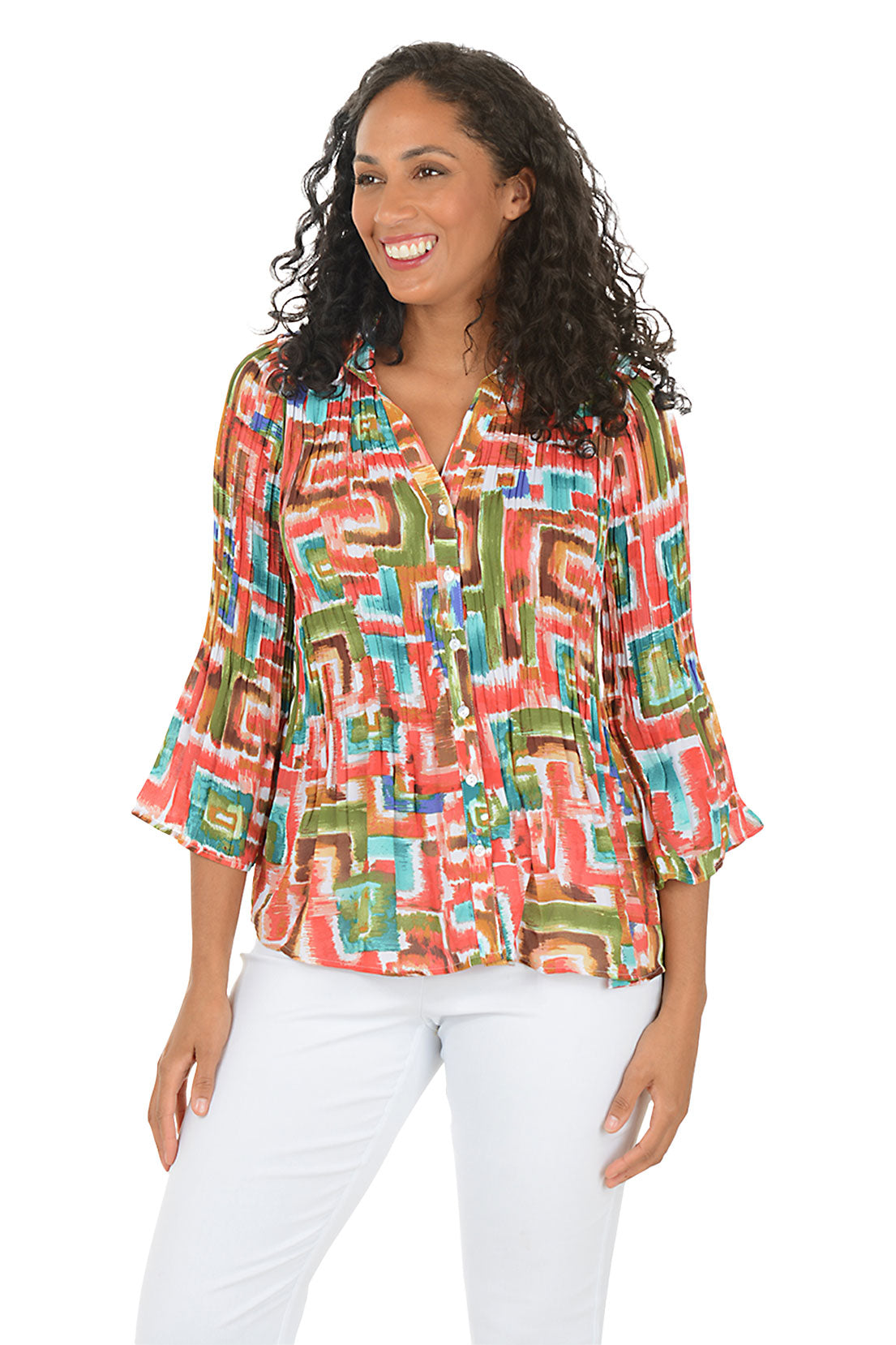 Woman wearing a colorful patterned blouse with white pants on a white background. Second front shot.