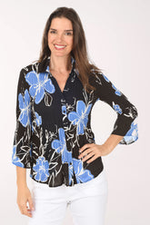 Woman wearing a black floral blouse with blue flowers on a white background