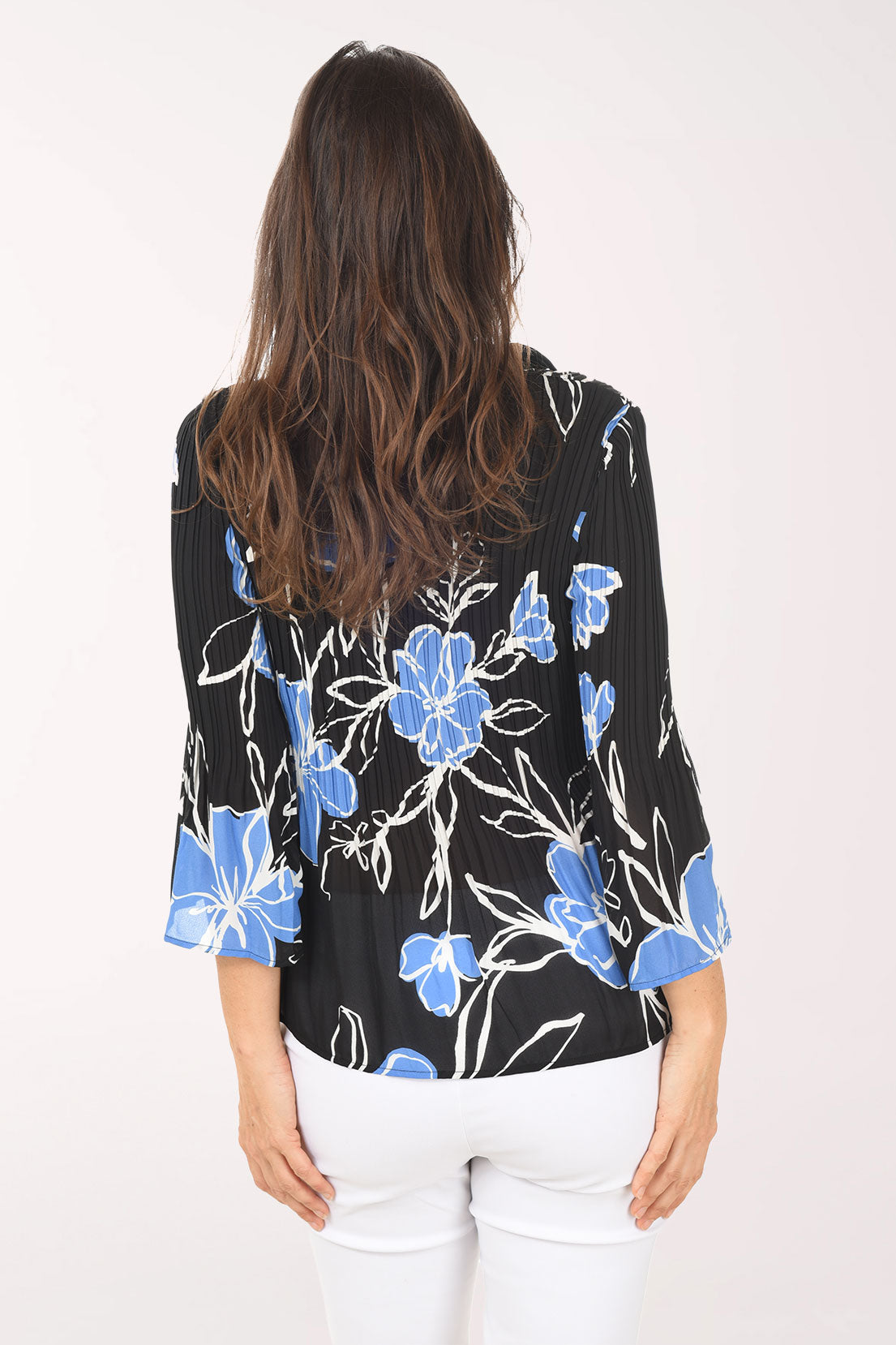 Woman wearing a black floral blouse with blue flowers on a white background