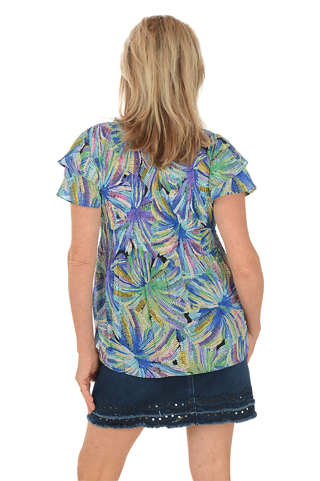 Woman wearing a colorful floral blouse with a white background. Back shot.