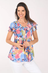 Woman wearing a colorful floral blouse on a white background