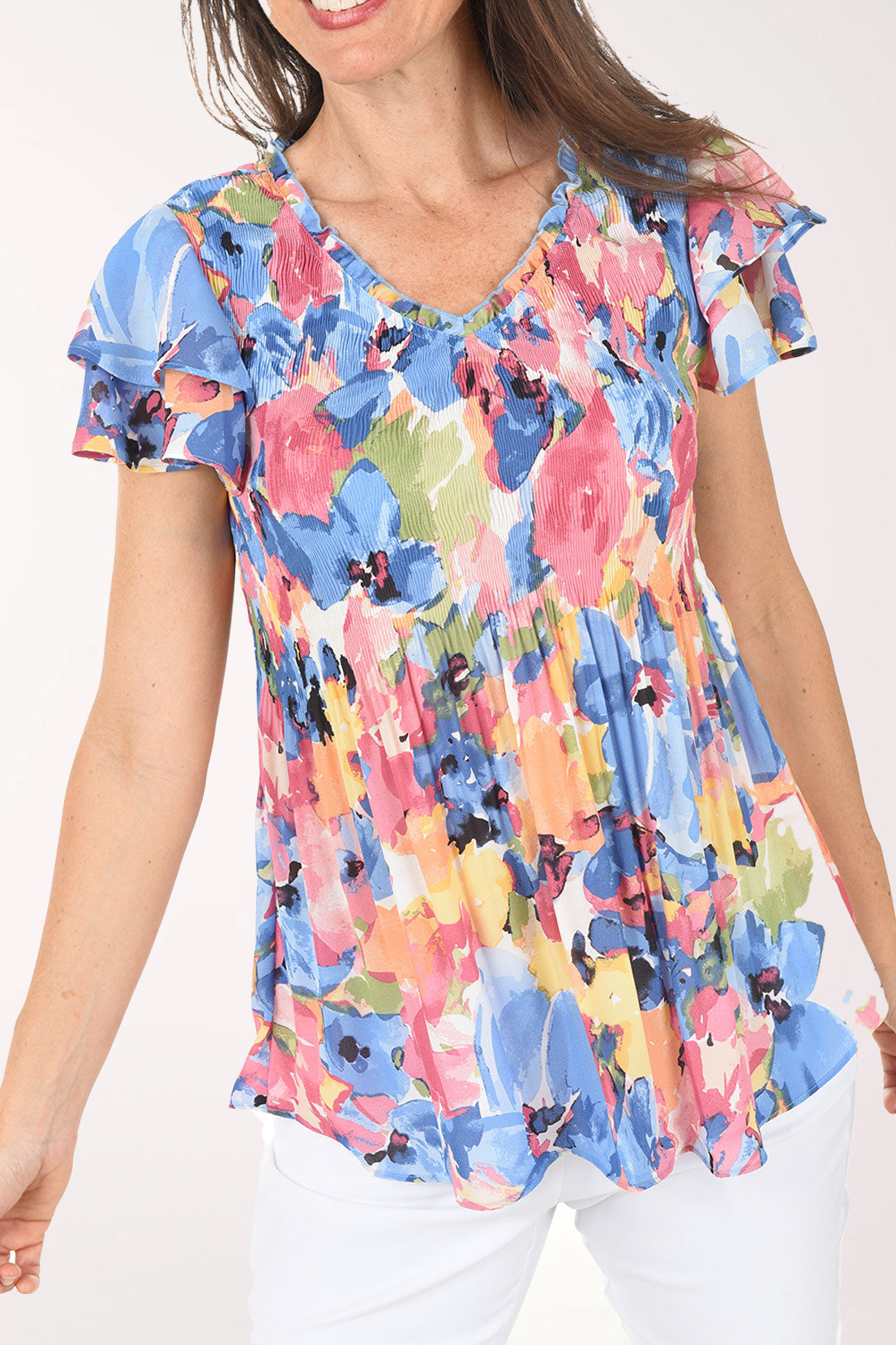 Woman wearing a colorful floral blouse on a white background