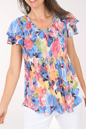 Woman wearing a colorful floral blouse on a white background