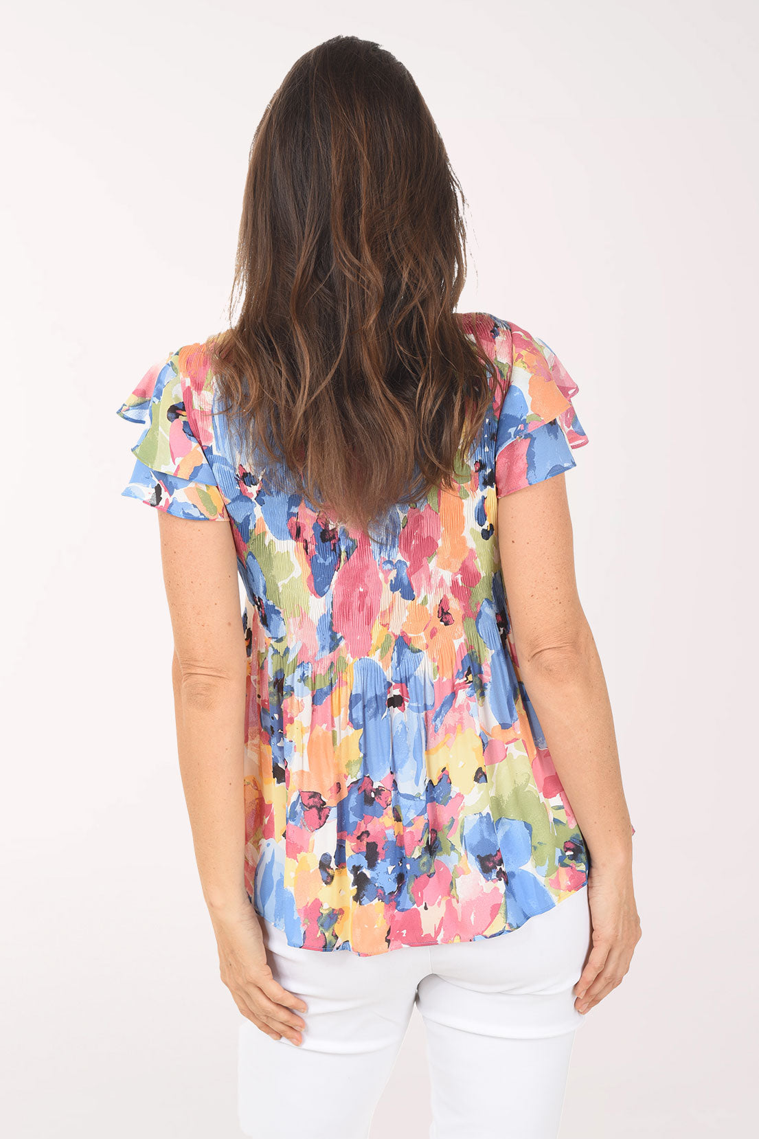 Woman wearing a colorful floral blouse on a white background