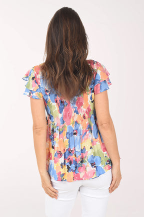 Woman wearing a colorful floral blouse on a white background