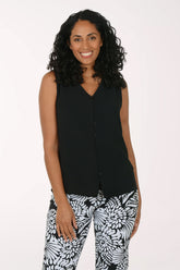 Woman wearing a black sleeveless top and patterned pants on a white background