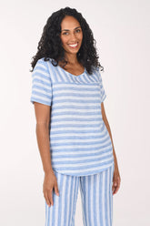 Woman wearing a blue and white striped pajama set on a white background