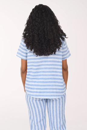 Woman wearing a blue and white striped pajama set on a white background