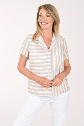 Woman wearing a striped shirt and white pants on a plain background
