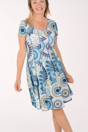 Woman wearing a blue and white patterned dress on a white background