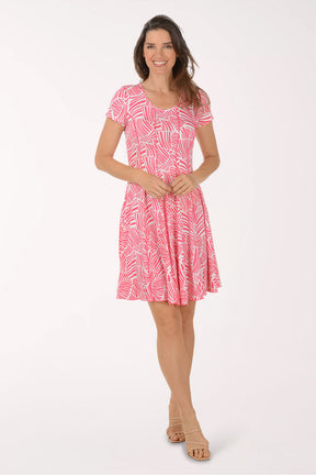 Woman wearing a pink patterned dress on a white background