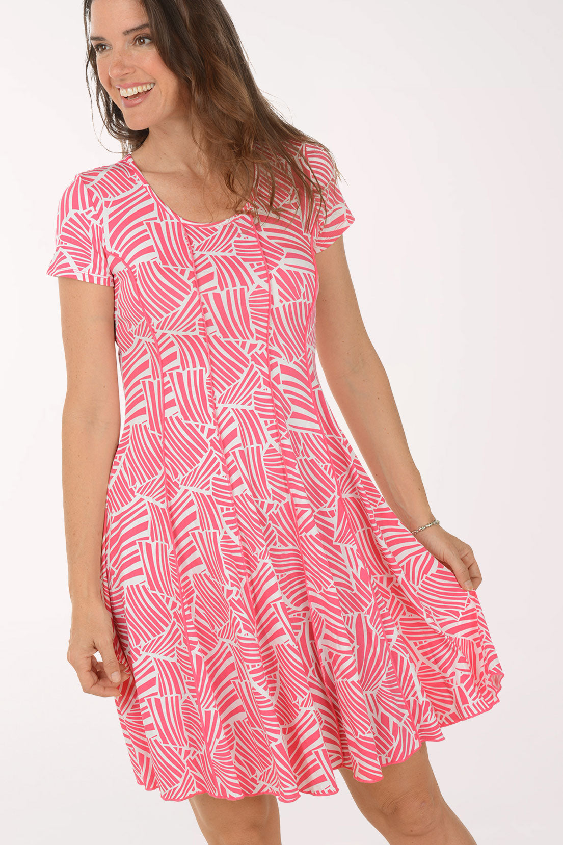 Woman wearing a pink patterned dress on a white background