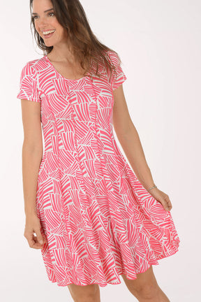 Woman wearing a pink patterned dress on a white background