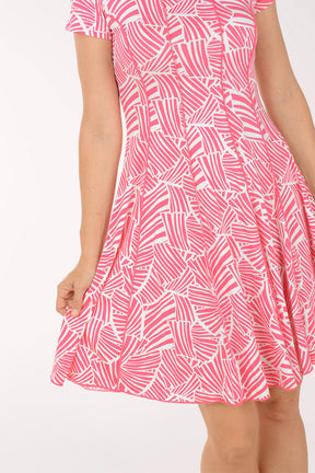 Woman wearing a pink patterned dress on a white background