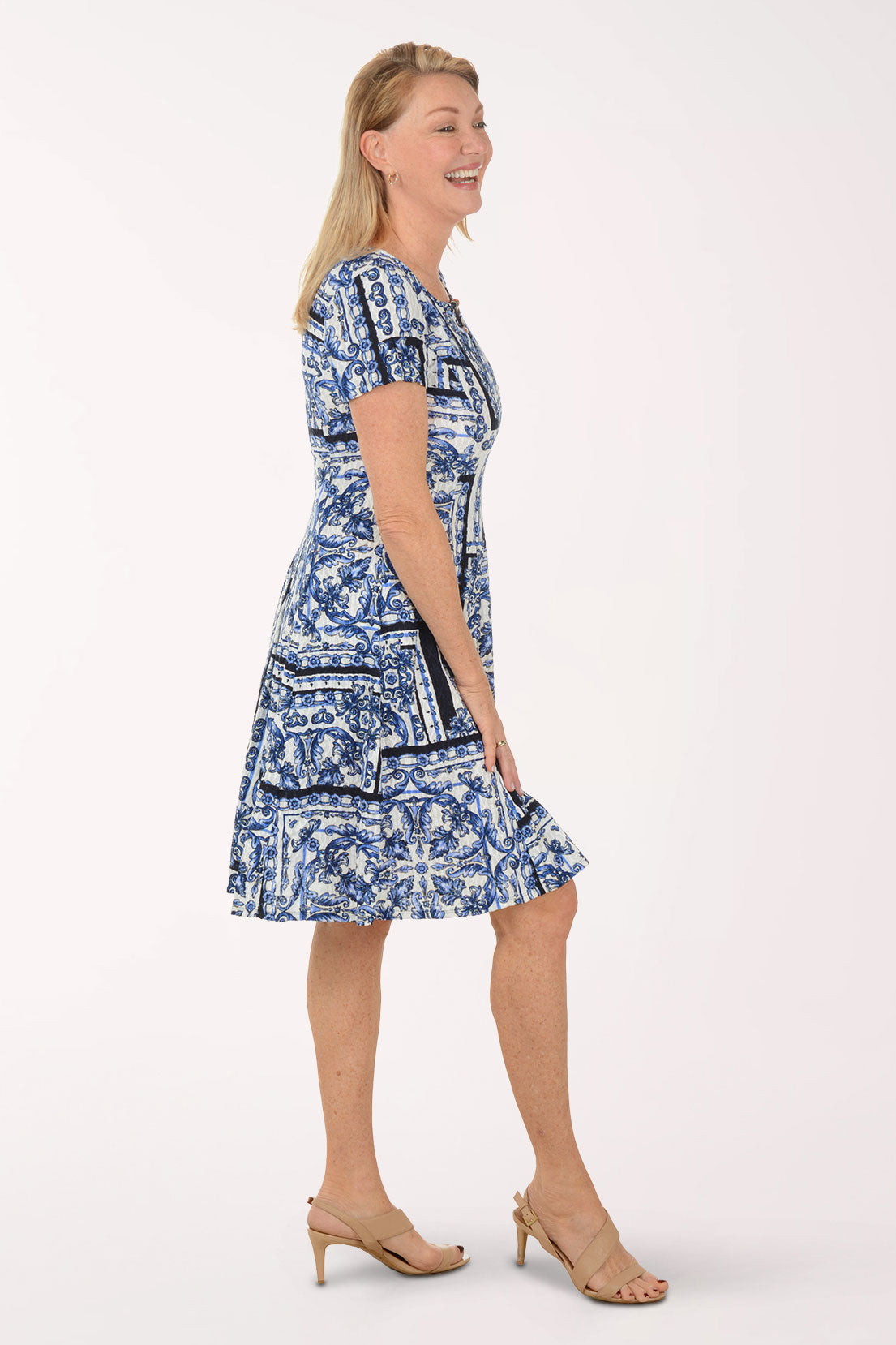 Woman wearing a blue patterned dress on a white background