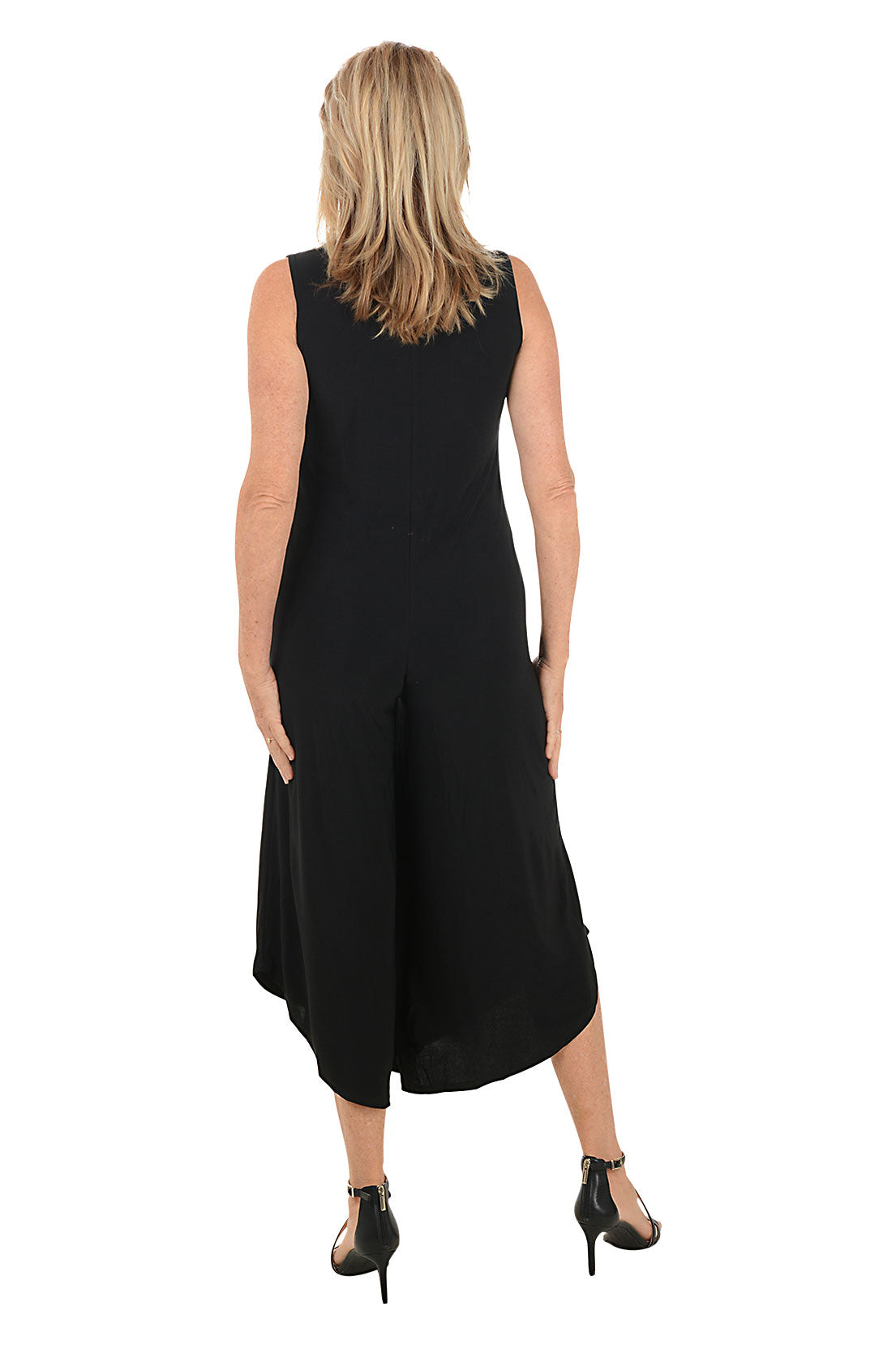 Woman wearing a black sleeveless jumpsuit with a zipper on a white background. Back shot.