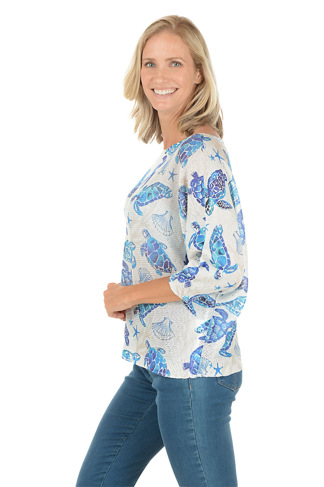 Woman wearing a blue turtle patterned shirt on a white background. Side shot.