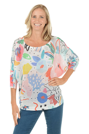 Woman wearing a colorful abstract patterned top on a white background.
