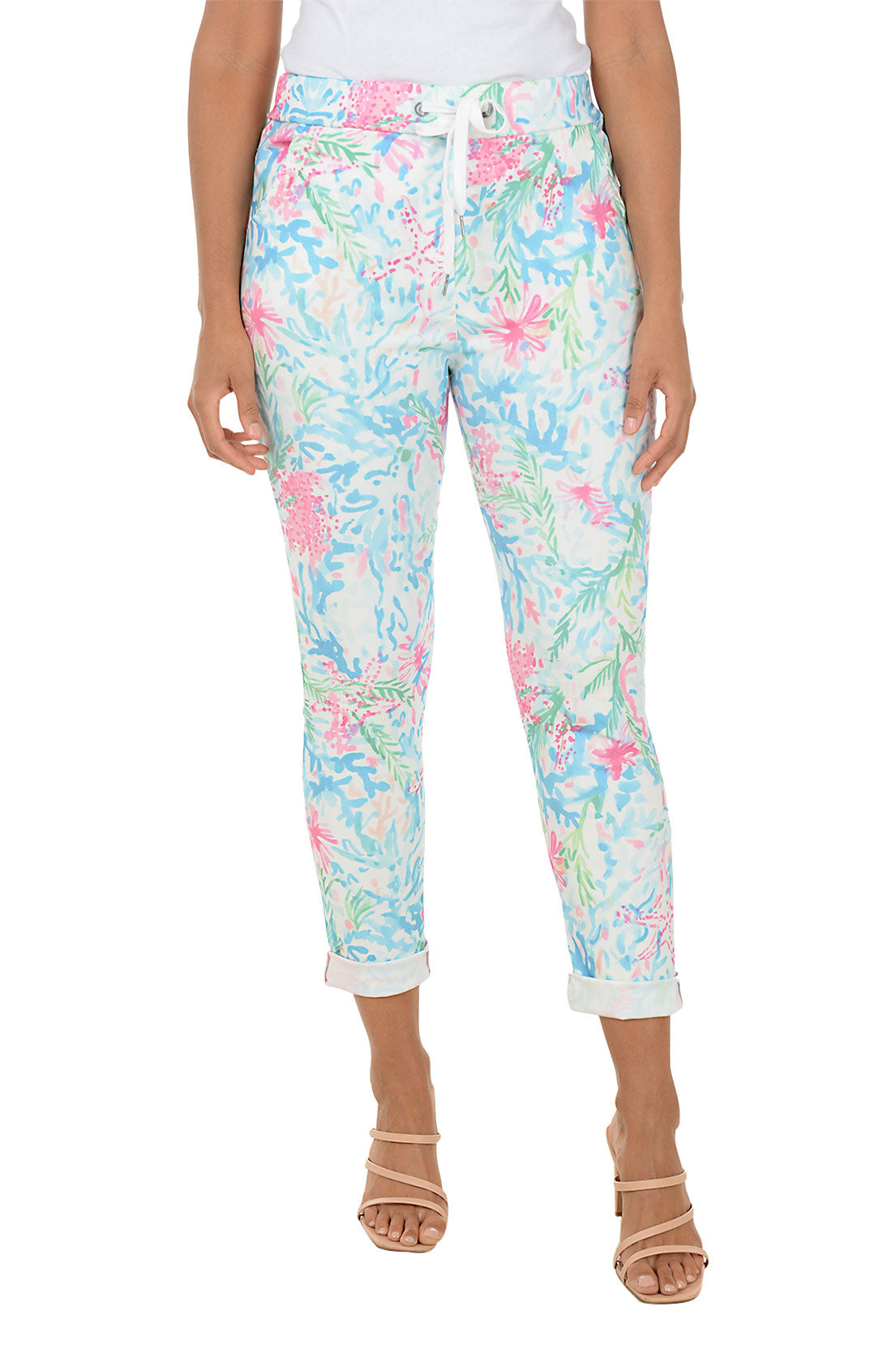 Person wearing colorful floral jogger pants on a white background.