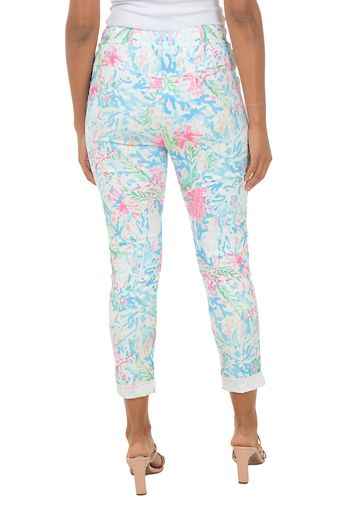 Person wearing colorful floral jogger pants on a white background. Back shot.