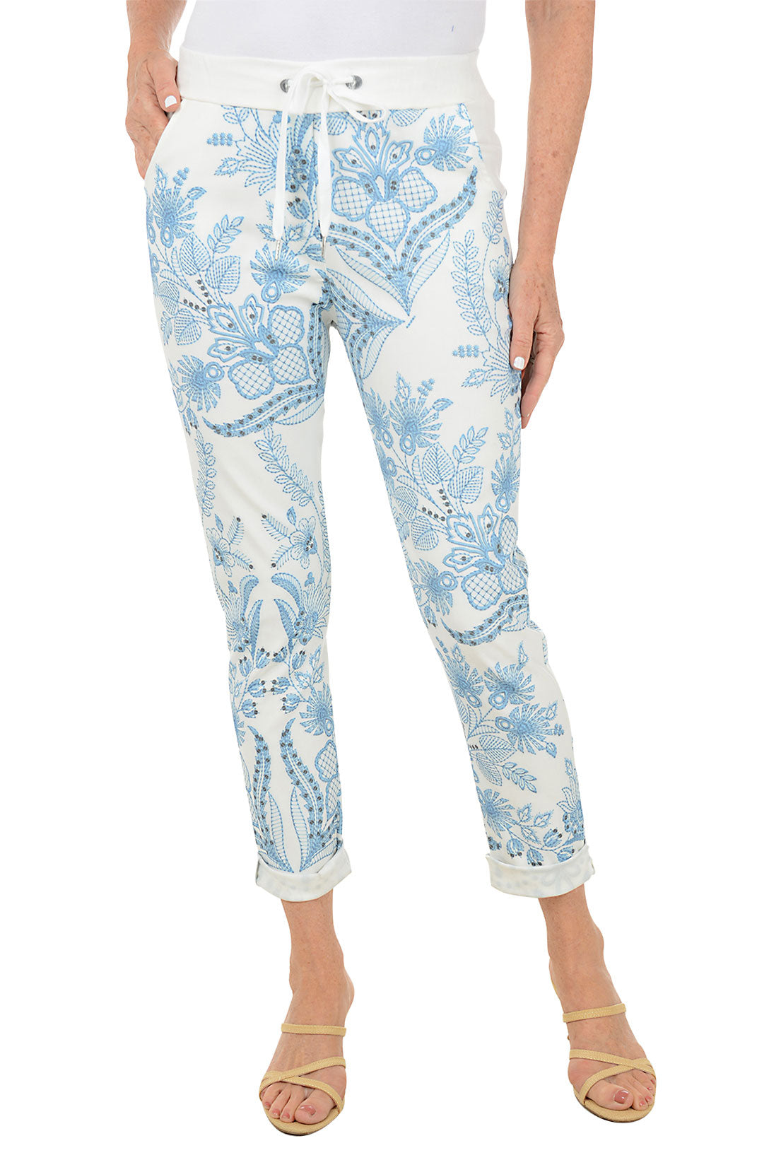 Light blue floral-patterned pants worn by a person on a white background.