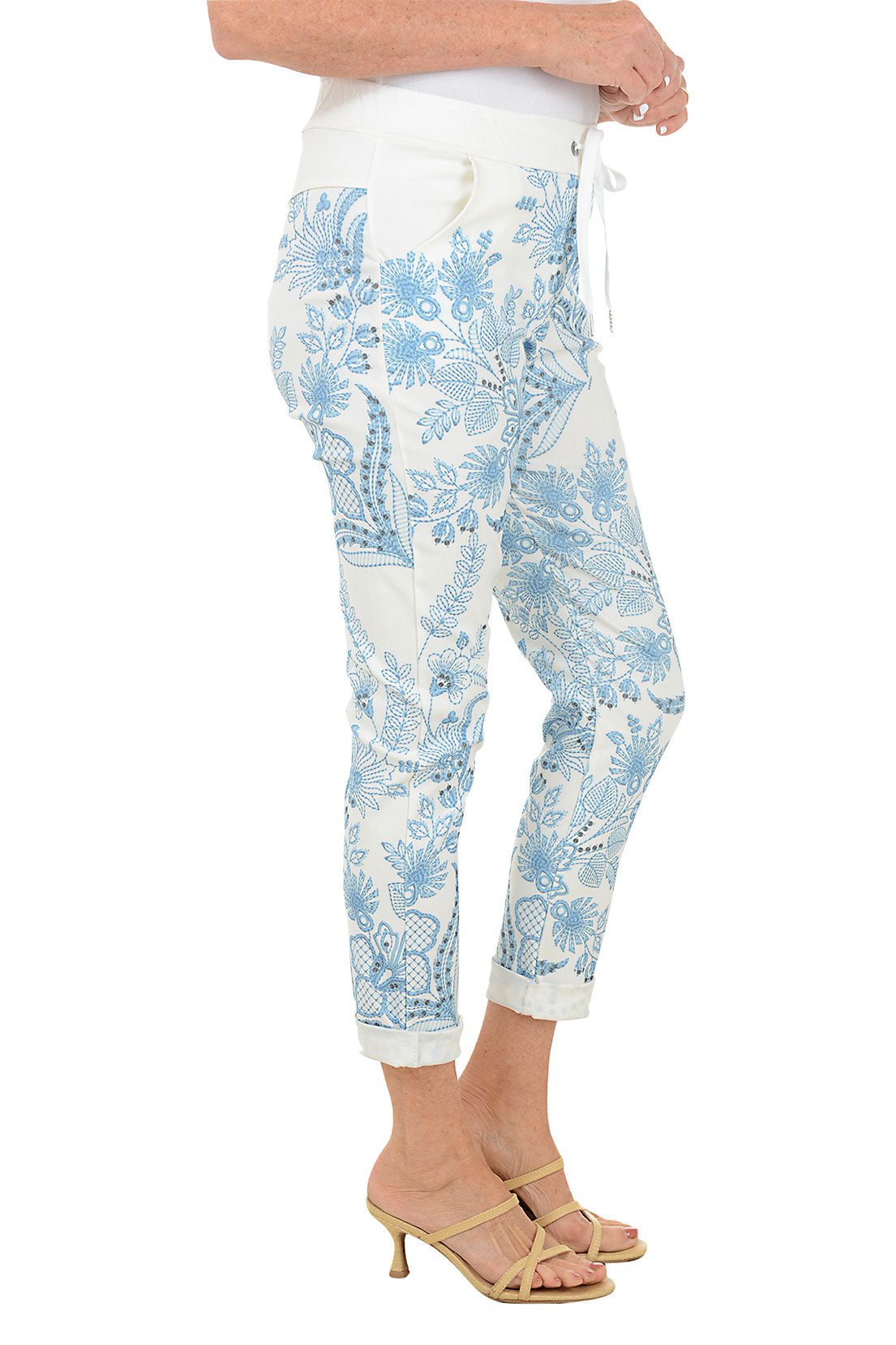 Light blue floral-patterned pants worn by a person on a white background. Side shot.