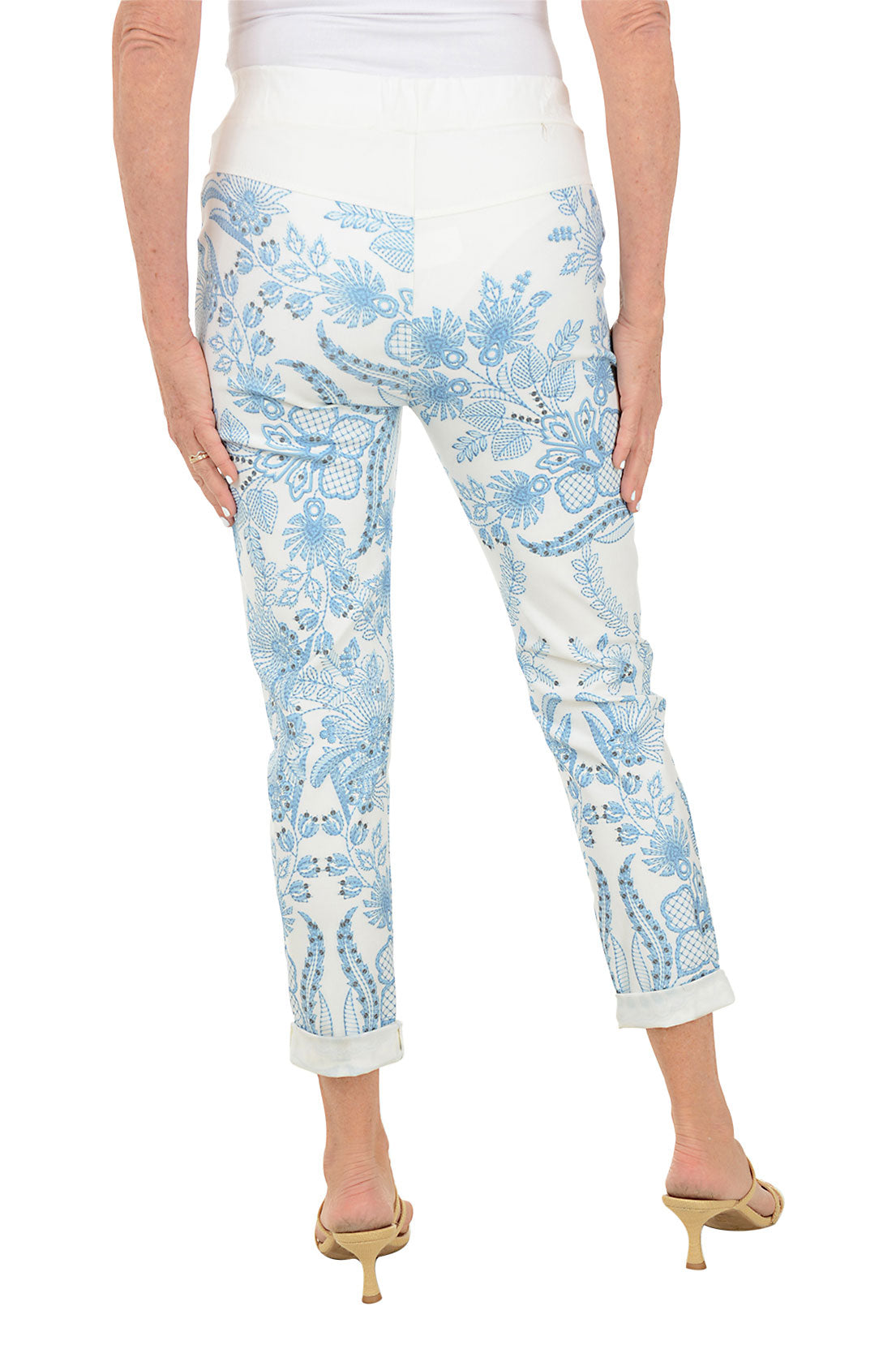 Light blue floral-patterned pants worn by a person on a white background. Back shot.