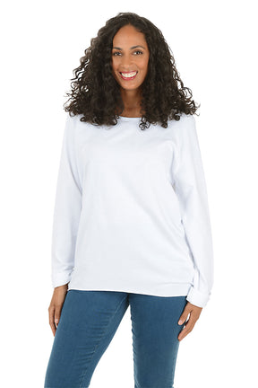 Woman wearing a white long-sleeve top and white pants on a white background.