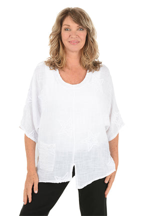Woman wearing a white blouse with black pants on a white background.