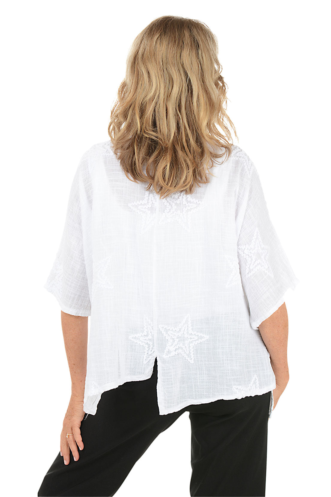 Woman wearing a white blouse with black pants on a white background. Back shot.
